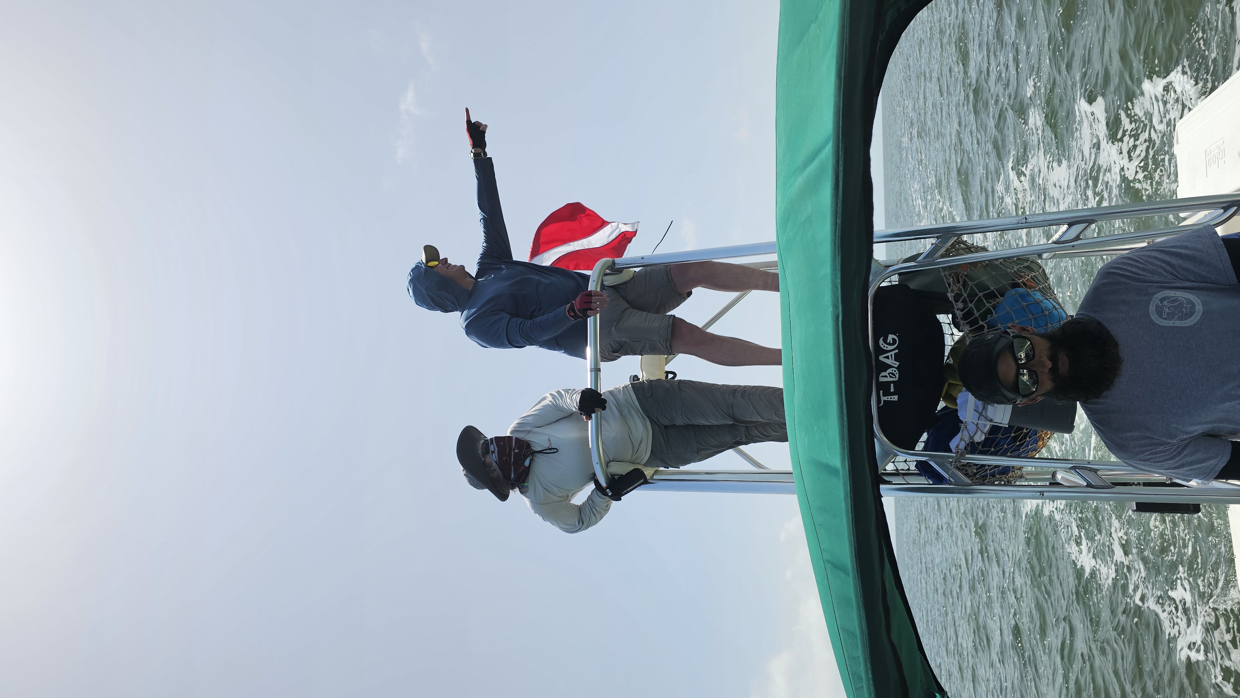 Field crew on the tower of a research vessel scanning for sea turtles in Florida Bay